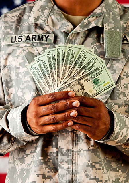 Soldier in uniform holding cash stack